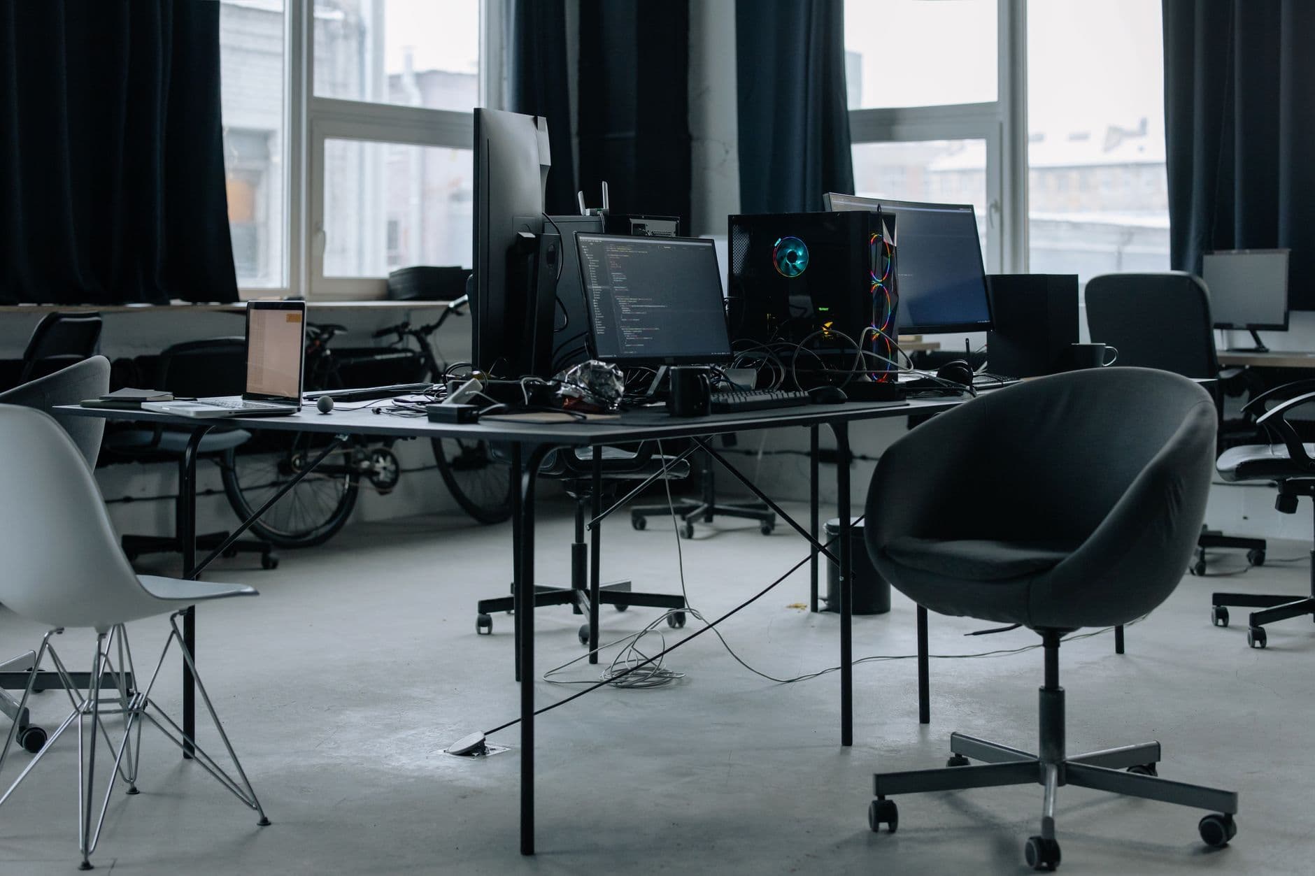 A darkened engineering floor, monitors lit at empty desks