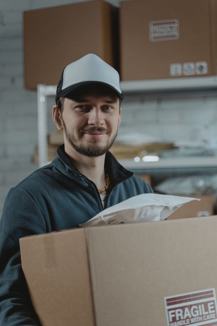 A warehouse operative holding a packed parcel