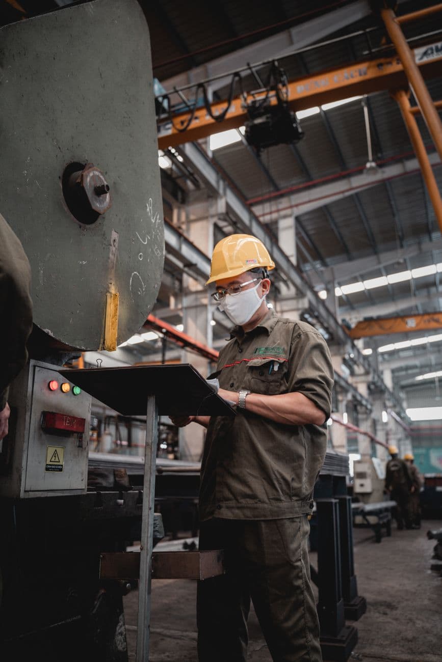 A supervisor with a clipboard on a factory floor