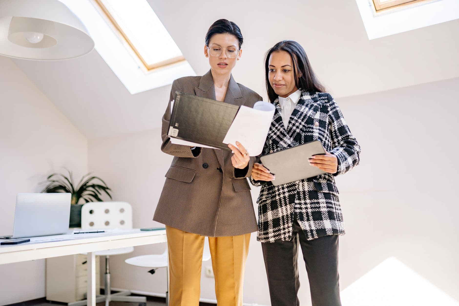 Two recruiters comparing notes while standing